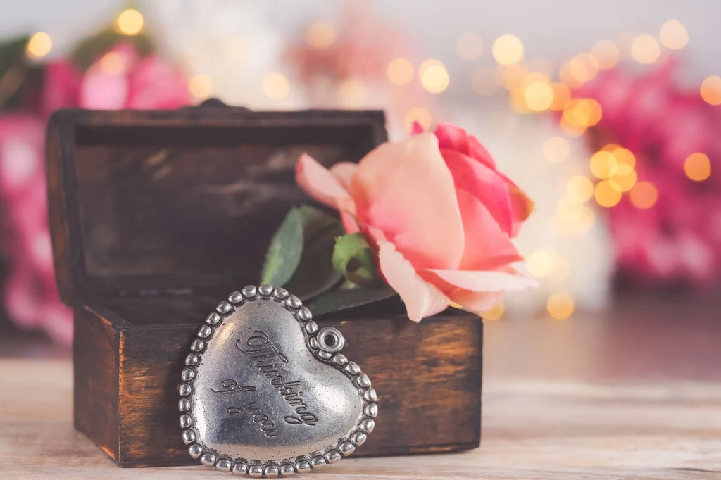 Heart-shaped pendant with Thinking of You text and a pink rose in a wooden box