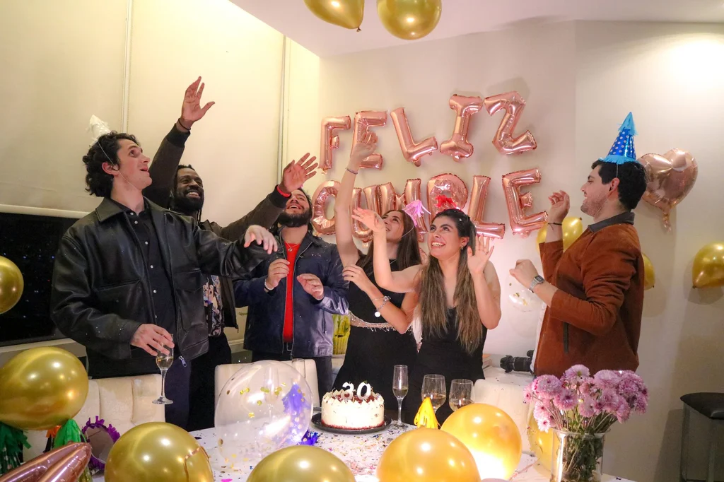 Friends celebrating a birthday indoors with balloons and cake — 21st birthday gift ideas (2026)